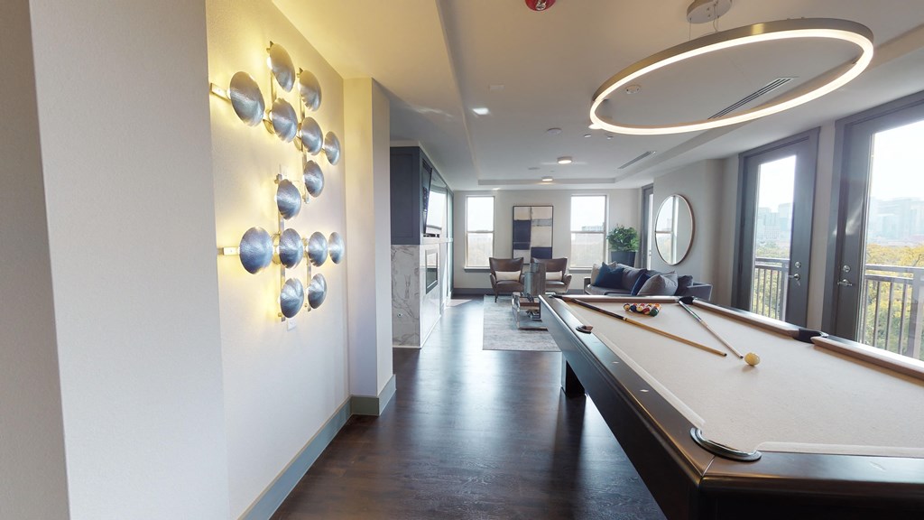 Resident sky lounge facing a pool table and sitting area complete with a television and fireplace.