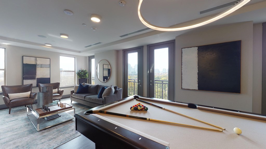 Resident sky lounge facing a pool table and sitting area complete with a television and fireplace.
