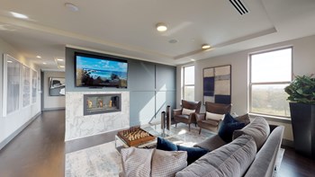 Resident sky lounge facing a table and sitting area complete with a television and fireplace. - Photo Gallery 60