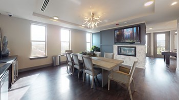 Resident sky lounge facing a table and sitting area complete with a television and fireplace. - Photo Gallery 61