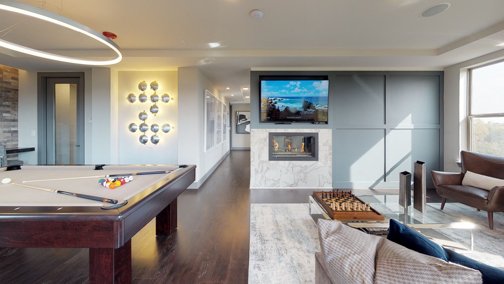 Resident sky lounge facing a pool table and sitting area complete with a television and fireplace.