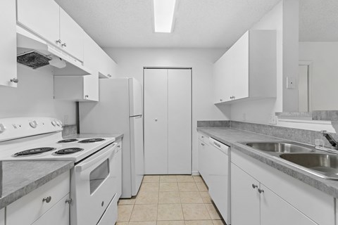 A kitchen with white appliances and cabinets.