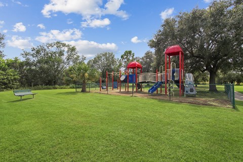 A playground with a red swing set and a blue slide.