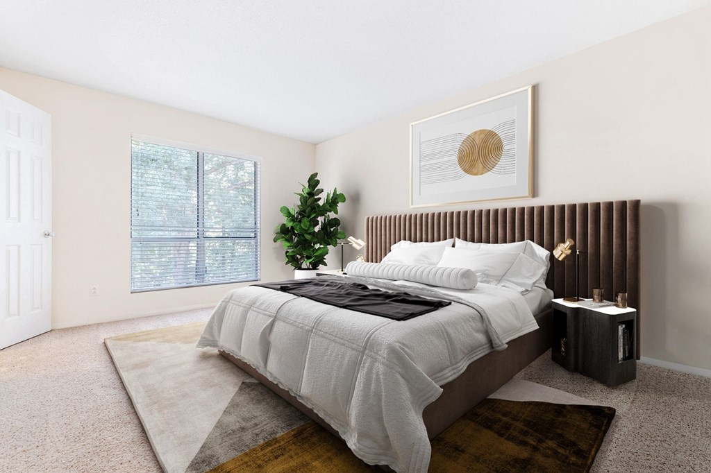 A bedroom with a large bed and a small tree. at Southpark Commons Apartment Homes, Charlotte, 28210