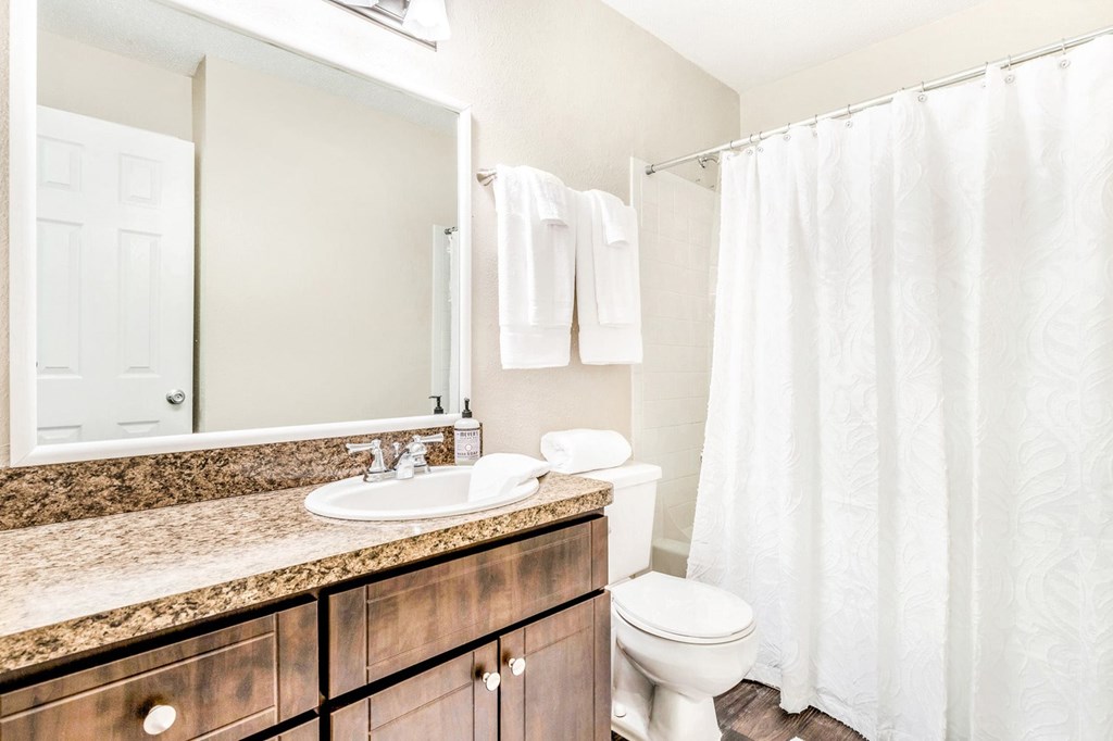 A white bathroom with a toilet, sink, and shower. at Southpark Commons Apartment Homes, Charlotte, NC, 28210
