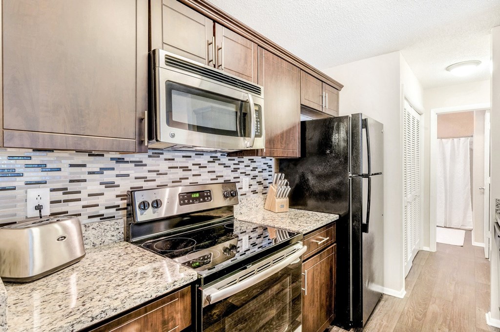 A kitchen with a black refrigerator, stove, and microwave. at Southpark Commons Apartment Homes, North Carolina
