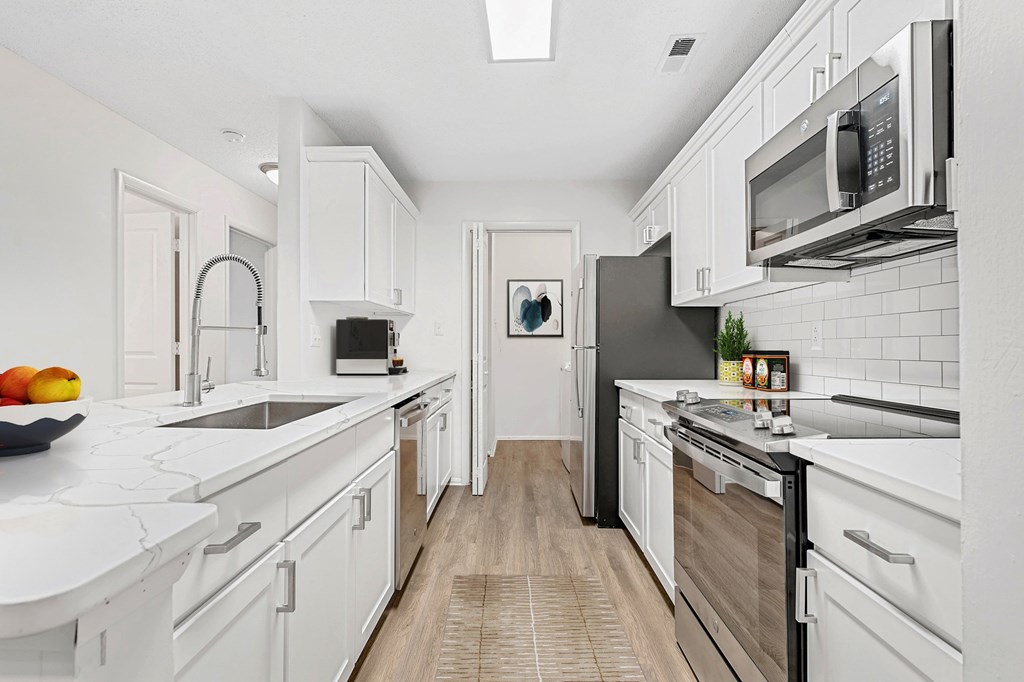 A modern kitchen with white cabinets and a black refrigerator. at Southpark Commons Apartment Homes, Charlotte, NC
