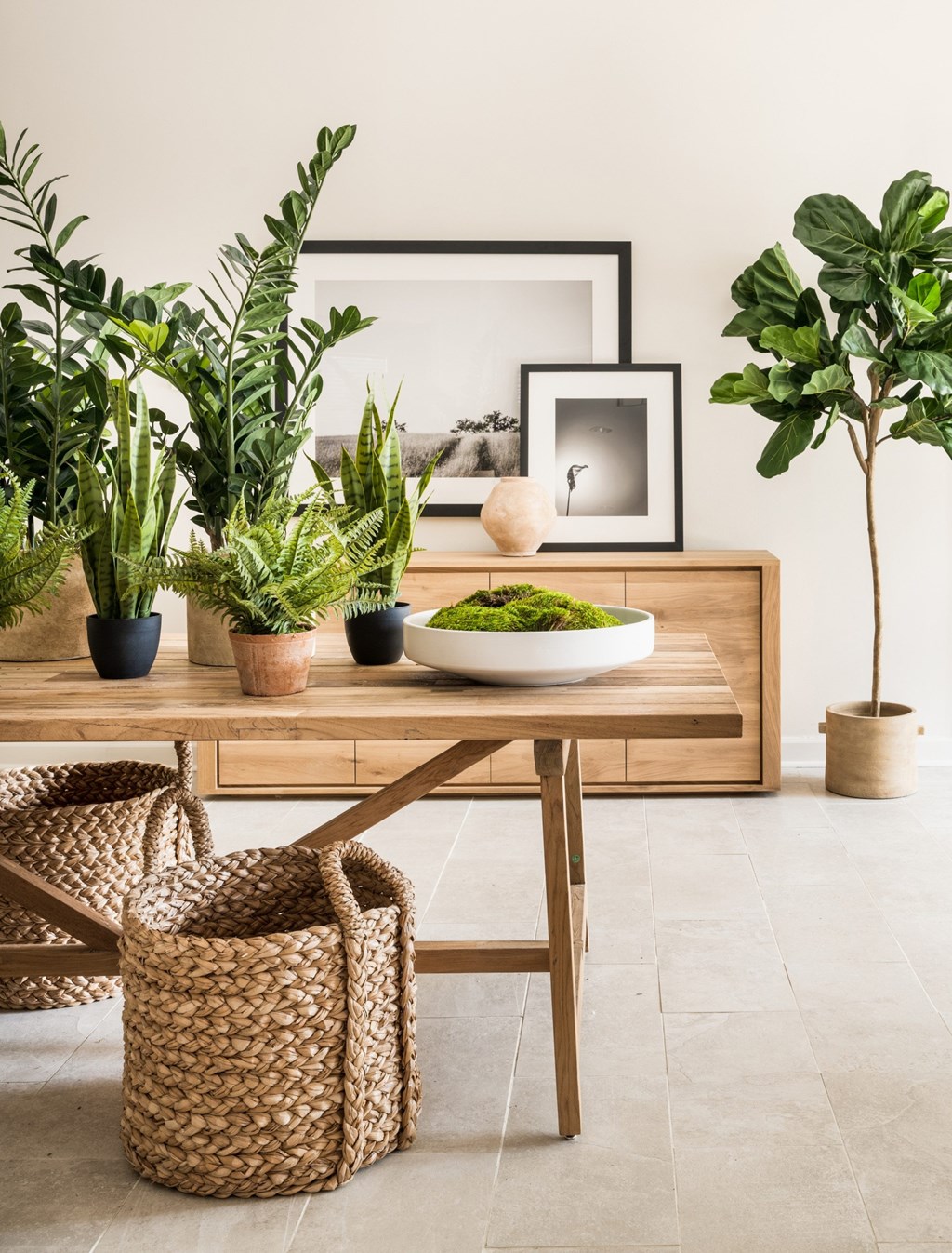 A wooden table with a bowl of green plants and a framed picture on it. at Southpark Commons Apartment Homes, Charlotte, NC, 28210