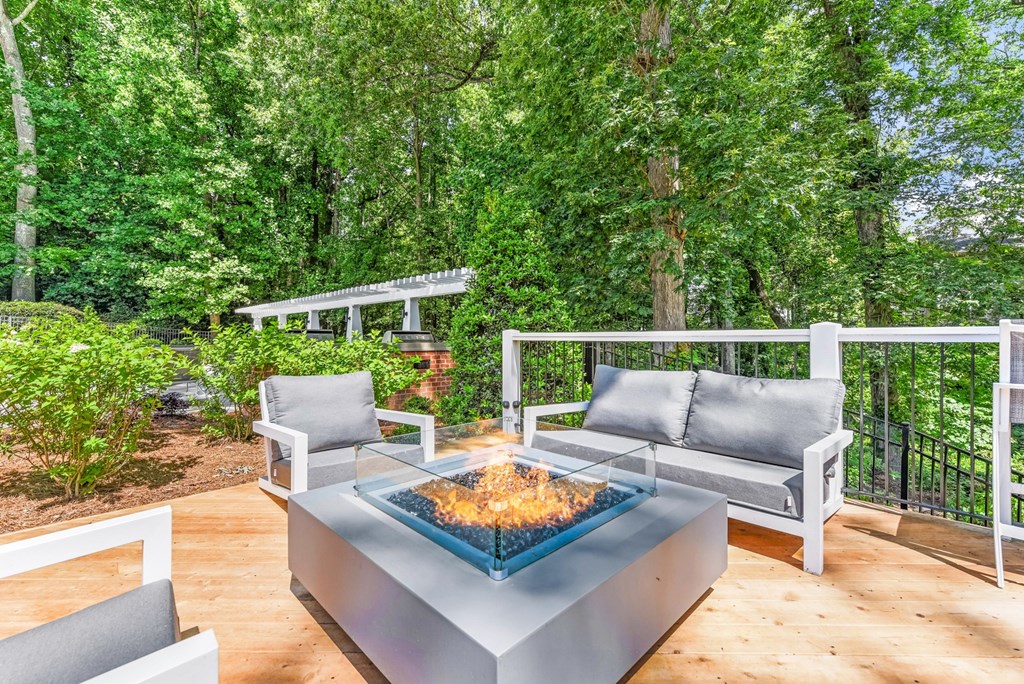 A modern outdoor seating area with a fire pit in the center. at Southpark Commons Apartment Homes, Charlotte, NC, 28210