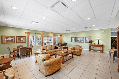 A spacious living room with a variety of furniture including a couch, chairs, and a coffee table.
