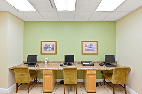 a computer lab with three computers on a long desk