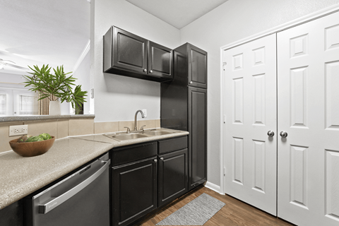 A kitchen with black cabinets and white walls.