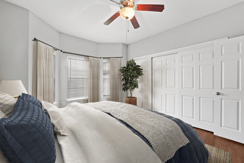 a bedroom with a large bed and a ceiling fan