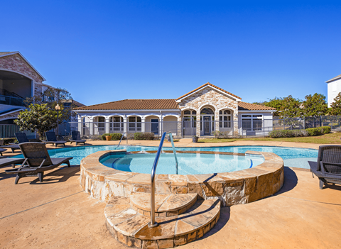 Heated spa and pool featuring the community clubhouse