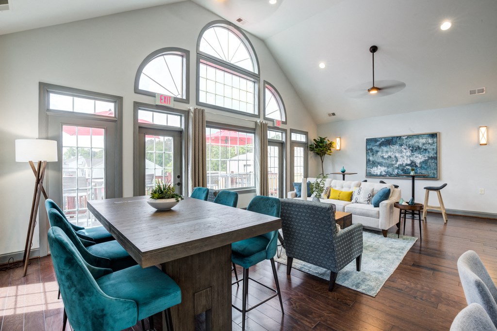 Leasing office with couches and long table with blue chairs