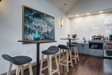 a kitchen with bar stools and a painting on the wall