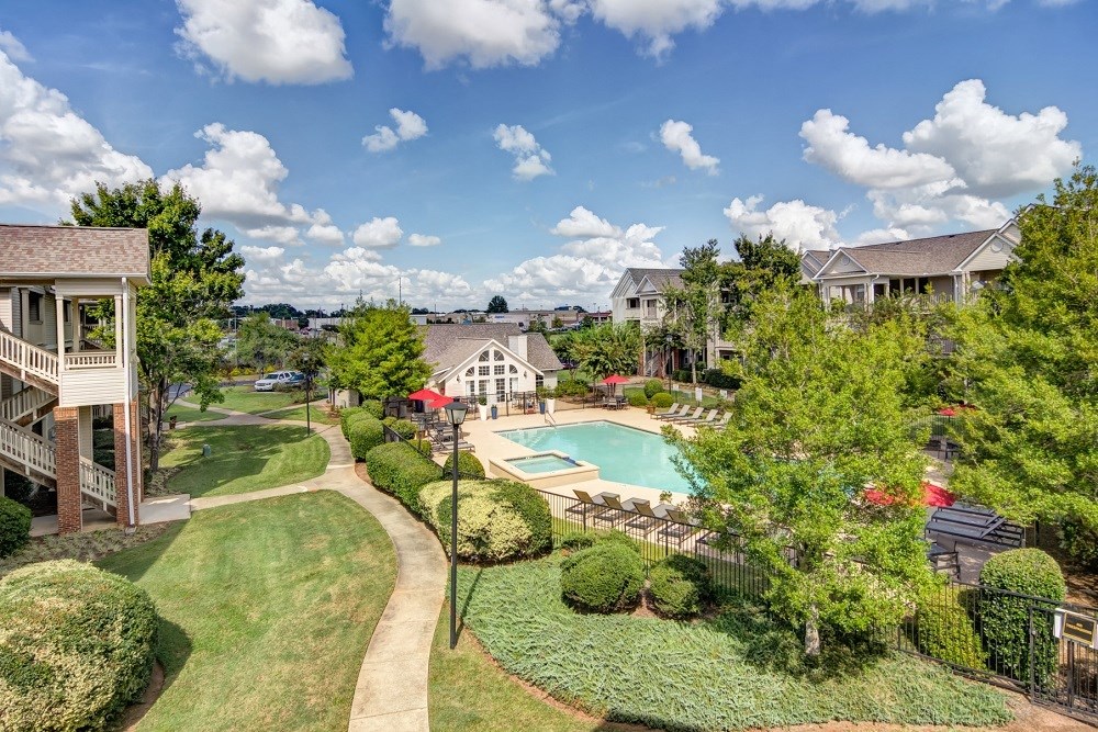 Exterior of buildings with grass and native trees, overlooking the swimming pool.