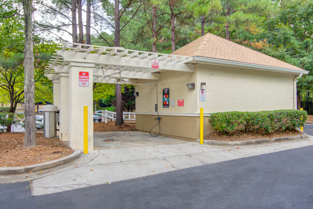 a gas station with a tan building and a yellow parking meter