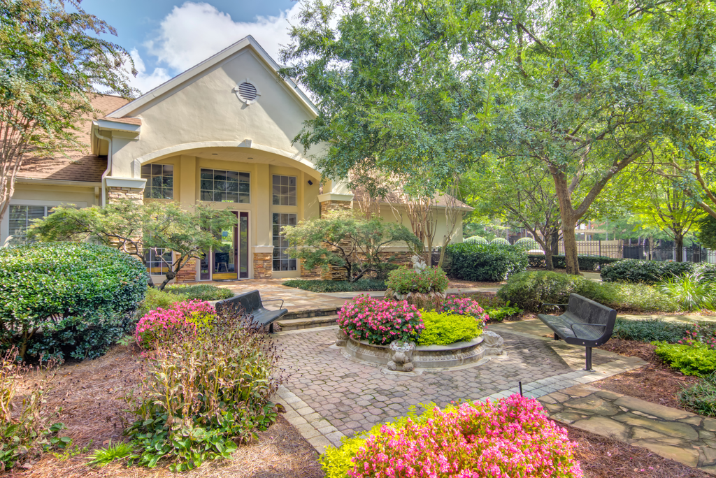 a house with a courtyard with flowers and trees
