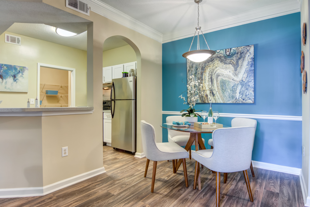 a dining room with a table and chairs and a refrigerator