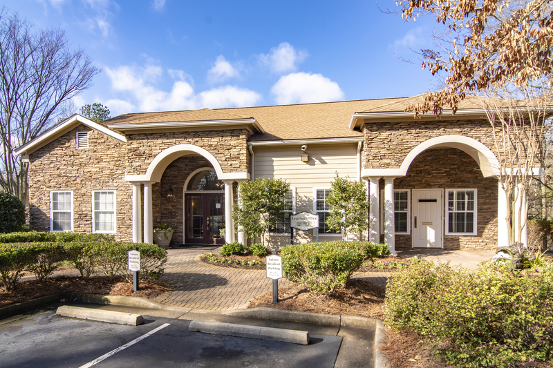 the front of a building with two archways and a driveway