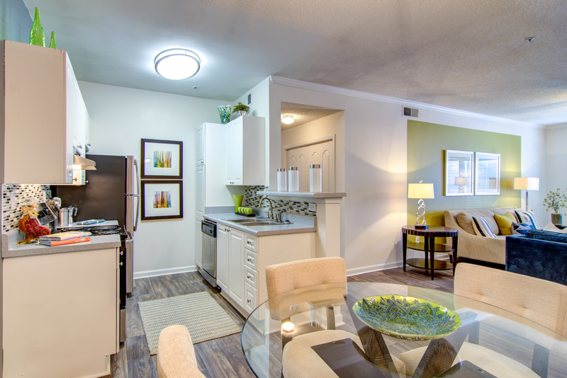 a living room and kitchen with a glass table and chairs