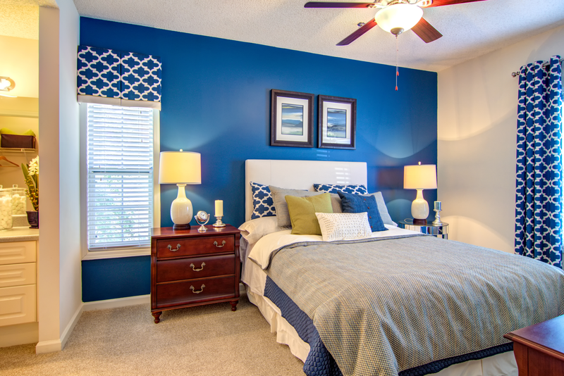 a blue and white bedroom with a bed and a ceiling fan