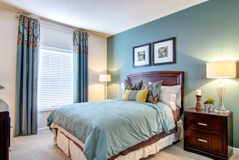 a bedroom with blue walls and a bed with pillows