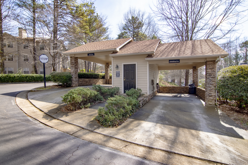 the front entrance of a building with a driveway and a parking lot
