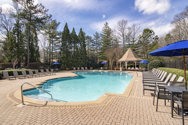 a swimming pool with chairs and umbrellas at the resort