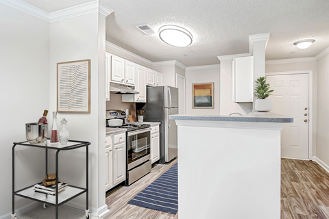 a spacious kitchen with white cabinets and stainless steel appliances