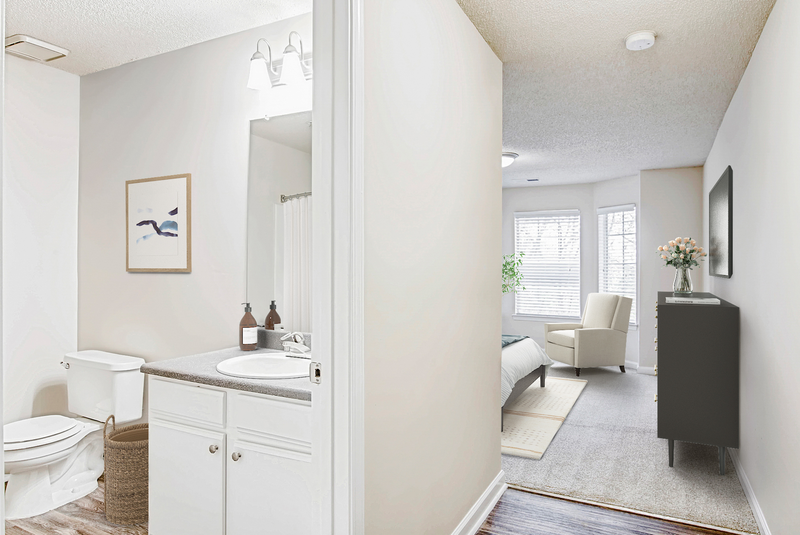 a bathroom with white walls and a white toilet next to a sink with a mirror above it