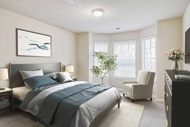 a bedroom with a large bed and a chair