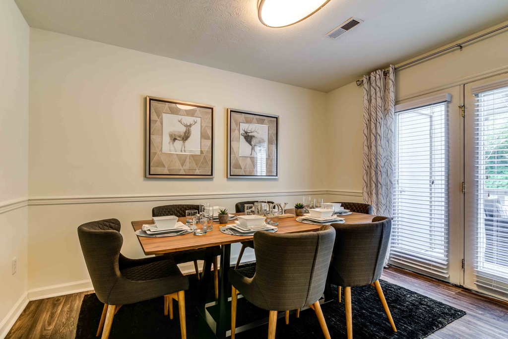 staged dining room with hardwood-style flooring and patio door