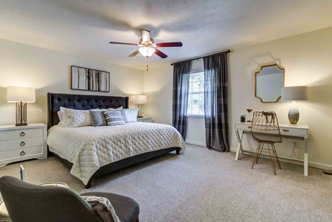 staged bedroom with carpeted flooring, lighted ceiling fan, and window