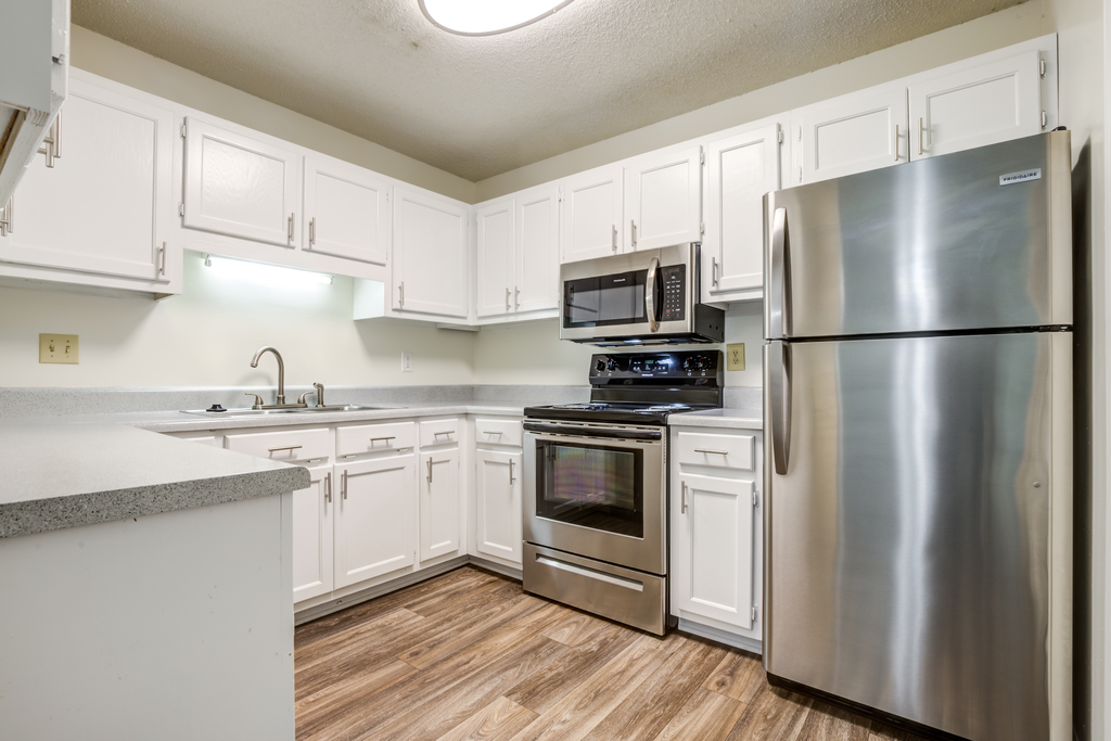 kitchen with white cabinetry, stainless appliances, and hardwood-style flooring
