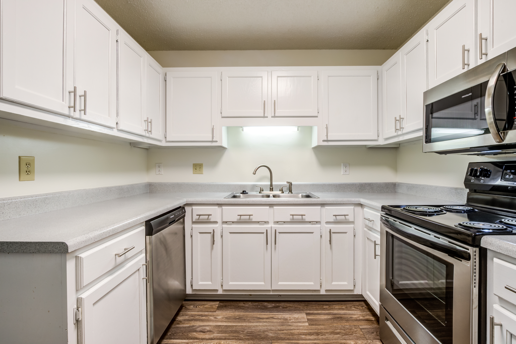 kitchen with white cabinetry, stainless appliances, and hardwood-style flooring