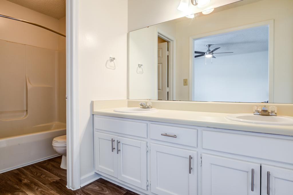 bathroom with white cabinetry and hardwood-style flooring