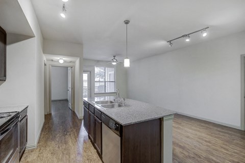 Kitchen island and dining area with wood style flooring, granite countertop, track lighting, large windows with mini blinds and ceiling fan with light