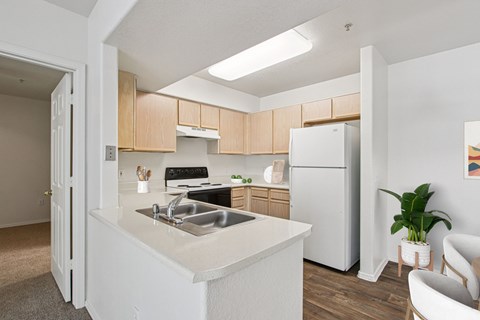 A kitchen with a white counter top and a white refrigerator.