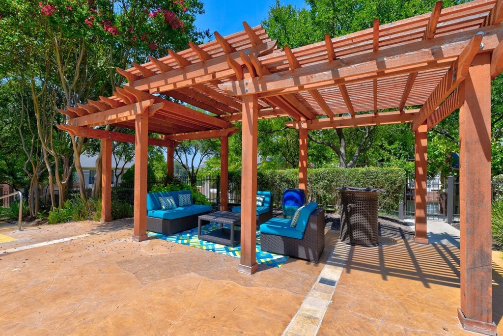 a wooden pergola with seating area