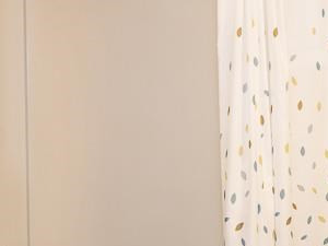Model Bathroom with White Shower Curtain Brown Cabinets and Tan Counters