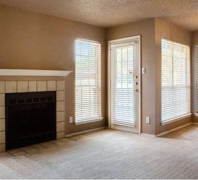 carpeted living room with a fire place and mantle