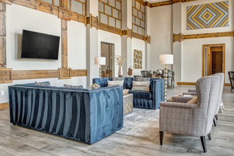 A living room with a blue sofa and a grey armchair.
