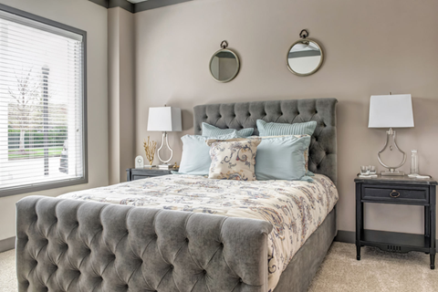 A bedroom with a large bed and two lamps.
