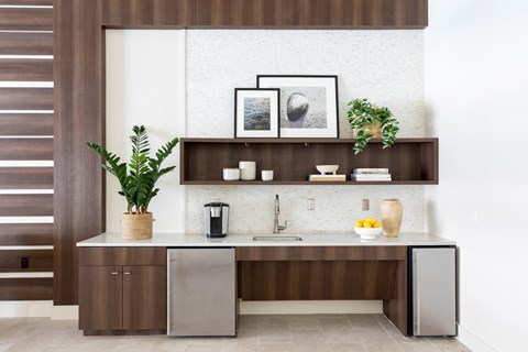 A modern kitchen with a wooden cabinet and a white backsplash.