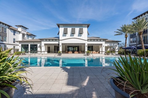 A large white house with a pool in front.