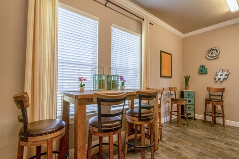 A dining room with a table and chairs.