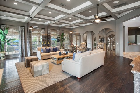 A spacious living room with a white sofa and a rug.