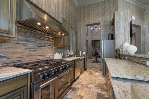 A kitchen with a stove top oven and a tile floor.